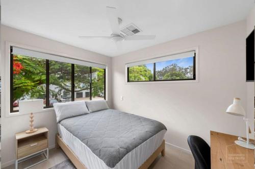 布里斯班Room to rent at the Glasshouse Mountains - Wifi的一间卧室设有一张床和两个窗户。