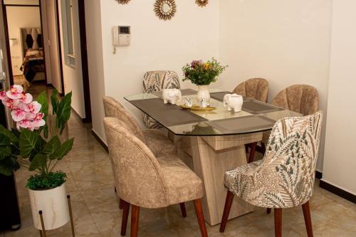 库斯科Departamento Familiar Equipado的一间设有玻璃桌和椅子的用餐室