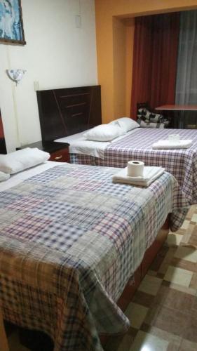 万卡约HOTEL MAJHAMI的配有两张床的酒店客房,并备有托盘