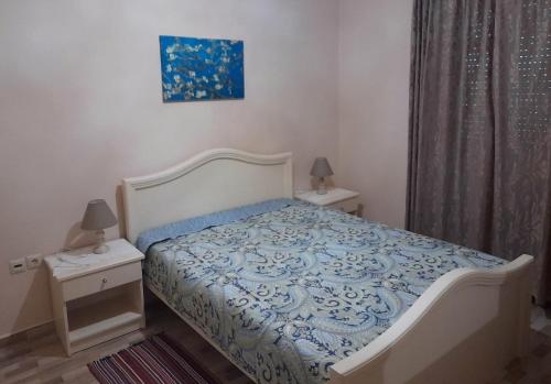 雷夫科斯卡尔帕索Pothitis villa的一间卧室配有一张带蓝色和白色棉被的床