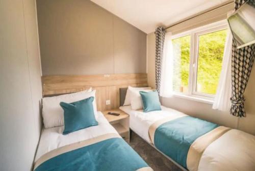 滨海纽比金Sandy Bay Lodge的小型客房 - 带2张床和窗户