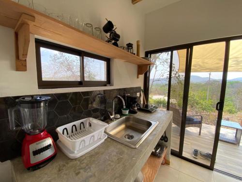 马塔帕洛Cozy Cottage on hilltop near Conchal - Casa Huella的厨房配有水槽和带窗户的台面