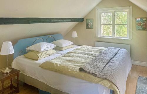 Sköldinge3 Bedroom Pet Friendly Home In Skldinge的一间卧室配有一张带蓝色床头板和枕头的床。