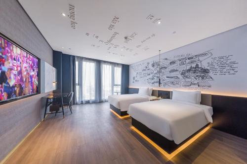 上海上海浦江联航路CitiGO欢阁酒店的酒店客房设有两张床,墙上挂有绘画作品