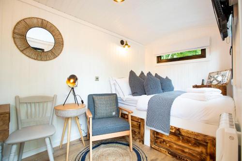 德里门The Mar Huts - The Lomond Hut的一间卧室配有一张床、一把椅子和镜子