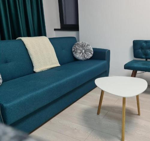 巴克乌Apartament de lux Bacău的客厅里设有一张蓝色的沙发和一张桌子