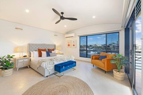 达尔文Marina View - Waterfront Stunner with Plunge Pool的一间卧室配有一张床、一张沙发和一个窗口