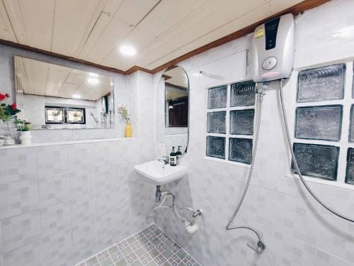 大城河畔青青民宿的带淋浴和盥洗盆的白色浴室