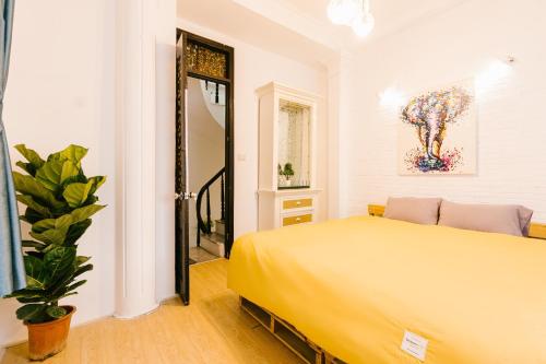河内Hi.Home Old Quarter Big Group 1min Ta Hien的一间卧室配有黄色的床和植物
