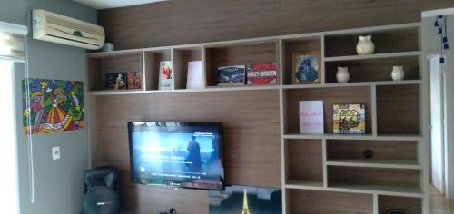 南卡希亚斯Apartamento na Serra Gaúcha的客厅设有木墙,配有平面电视。