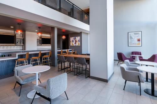 奥斯汀Atwell Suites Austin Airport, an IHG Hotel的一间带桌椅的餐厅和一间酒吧