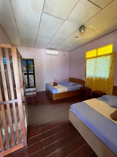 刁曼岛SALANG SAYANG RESORT , PULAU TIOMAN的客房设有两张床和窗户。