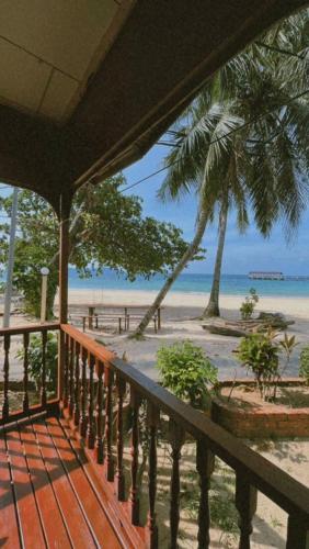 刁曼岛SALANG SAYANG RESORT , PULAU TIOMAN的阳台享有棕榈树海滩的景致。