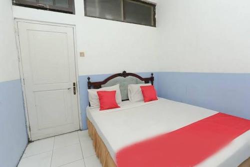 贝努阿亚尔Hotel Kharisma的一间卧室配有一张带红色枕头的床