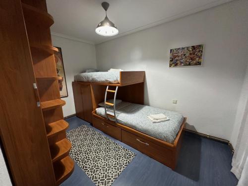萨龙El pisuco的小房间设有双层床和椅子