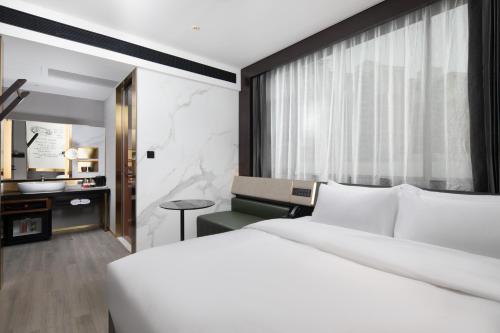 深圳深圳福田下梅林地铁站CitiGO欢阁酒店的卧室配有一张白色大床和一张书桌