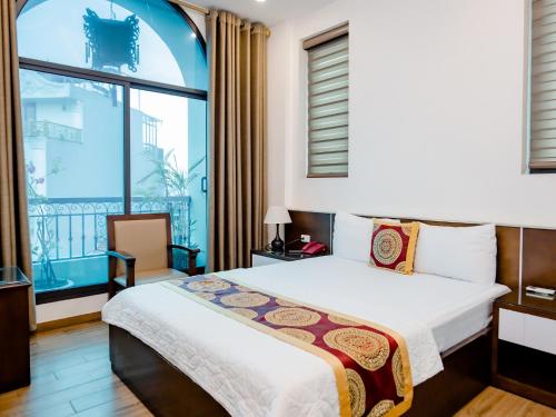 河内Phuong Nam Luxury Hotel Long Bien的一间卧室设有一张床和一个大窗户