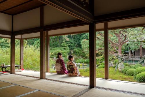 京都OMO3 Kyoto Toji by Hoshino Resorts的两个和服的女人站在窗子外面