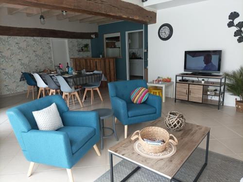 谢尔河畔圣乔治Gîte La Grange 9 pers的客厅配有2把蓝色椅子和桌子