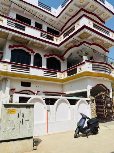 AyodhyaShri SeetaRam Home Stay Near Shri Ram Janmabhoomi Mandir Ayodhya的停在大楼前的摩托车