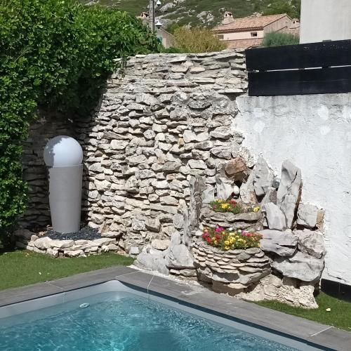 乐罗夫Chez Nous的石墙和院子内的游泳池
