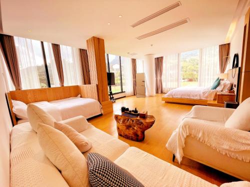张家界XMAN Valley Sunrise Resort的一个带两张床和一张沙发的大客厅