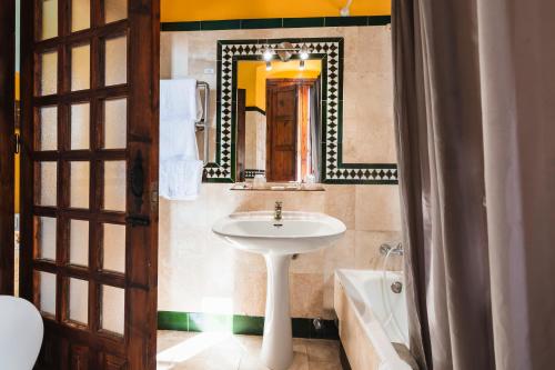 Pechina巴尔尼亚奥德塞拉利昂阿尔哈密拉酒店的浴室配有盥洗盆、镜子和浴缸