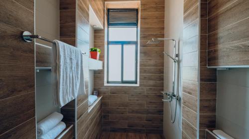 基加利ROOFTOP VIEW APARTMENTS REBERO的一间带木制墙壁和淋浴的浴室