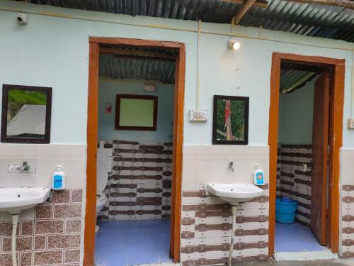 吉布Himtrek Camps Jibhi的墙上有2个水槽的浴室