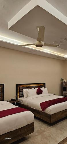 伊斯兰堡Burj Ul Zaki的一间卧室配有两张床和吊扇