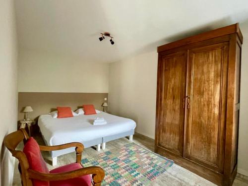 滨海拉库阿尔德Belle location Spa et grande terrasse privés的卧室配有白色的床和木制橱柜。