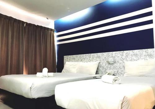吉隆坡Mozu Hotel Sri Hartamas的配有白色床单的酒店客房内的两张床