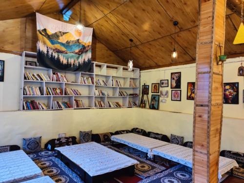 吉布Himtrek Camps Jibhi的一间设有桌子和书架的房间