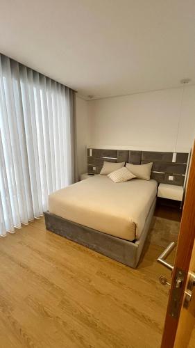 波尔图Coruja’s House AL OPO的一间卧室设有一张床和一个大窗户