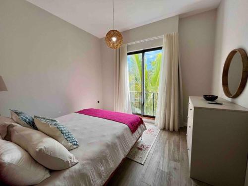 贝尔马尔Summer beachfront apartment的一间卧室配有一张带窗户和镜子的床