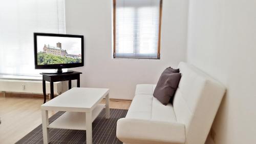 艾森纳赫Alte Uhrmacherei Eisenach的白色的客厅配有白色的沙发和电视