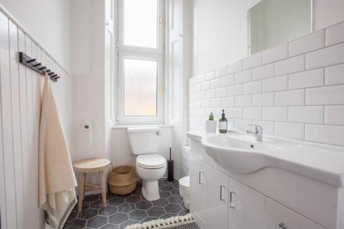 格拉斯哥Stunning 2 bed property in heart of West End的白色的浴室设有卫生间和水槽。