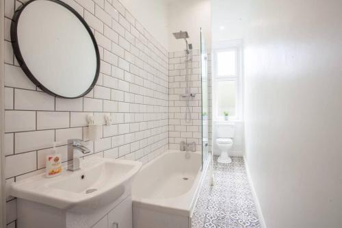 格拉斯哥Modern, Light-filled and Sleek West End Apartment的白色的浴室设有水槽和镜子