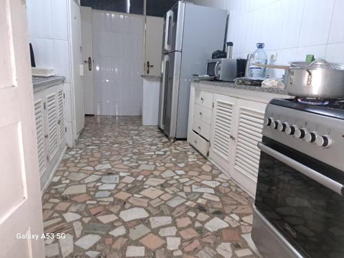 贝拉Yulendo的带冰箱的厨房和瓷砖地板。