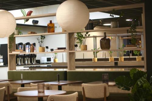 奥斯陆奥斯陆智能酒店的一间设有桌椅和盆栽的餐厅