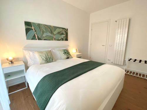 多莫多索拉Casa Dell'Edera - Holiday Apartment in Domodossola的卧室配有一张带绿毯的白色床