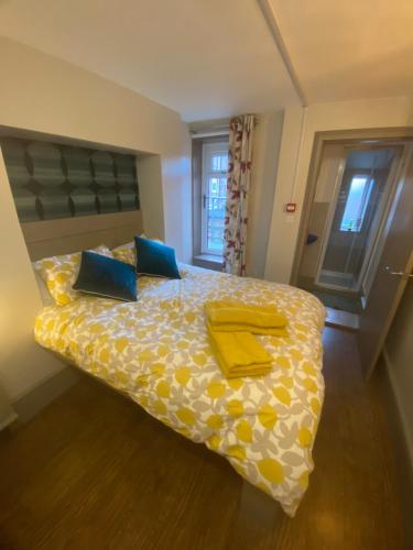 诺丁汉Quiet cosy 1 bedroom apartment Carrington F1的一间卧室配有一张带黄色床单和蓝色枕头的床。