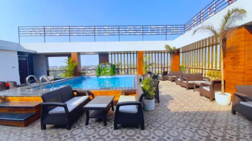 SiwānHotel Grand Patliputra的酒店庭院设有游泳池和桌椅