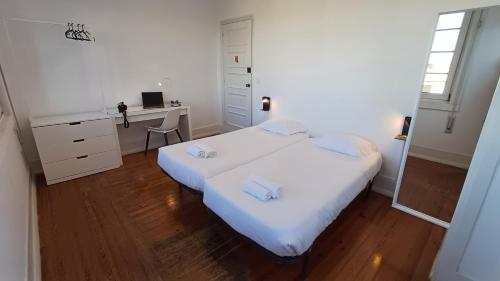 科英布拉HI Coimbra - Pousada de Juventude的白色卧室配有床和书桌