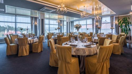 西格伏沙尔克Complex Katalina的宴会厅配有桌椅和吊灯。