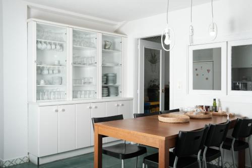 莱昂HOSTEL RUA 35的白色的厨房配有木桌和黑椅子