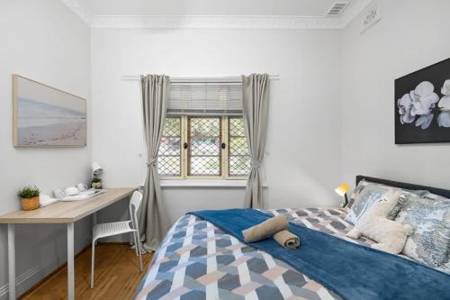 悉尼Lidcombe Boutique Guest House near Berala Station3的一间卧室配有一张床、一张书桌和一个窗户。