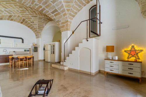 马蒂诺Relais Palazzo Zaccaria的大房间设有楼梯和桌椅