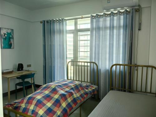 海口Cozy home of Orchid的一间卧室设有两张双层床和一扇窗户。