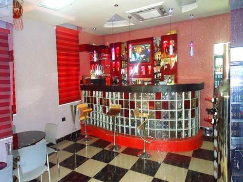伊凯贾Presken Hotel at International Airport Road的一间酒吧,拥有红色的墙壁和 ⁇ 格地板